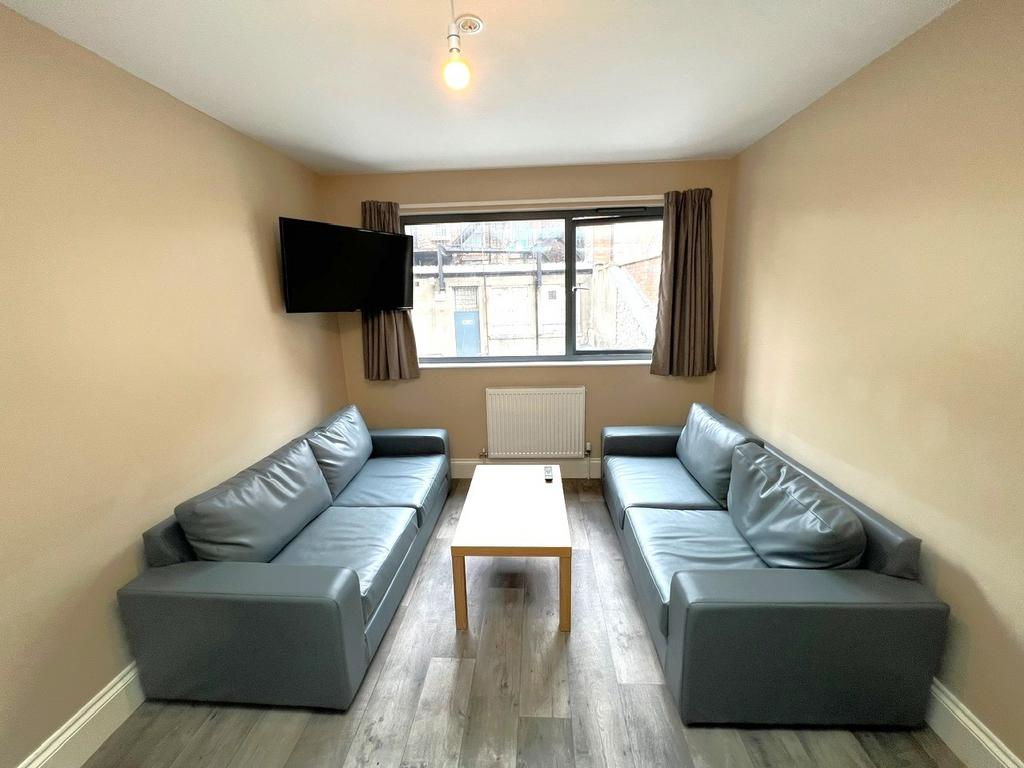 Neat communal lounge with two matching grey sof...