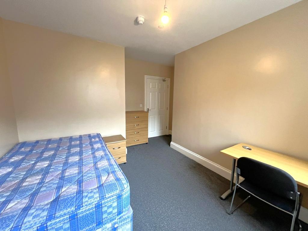 Bright, simply furnished single bedroom with a ...