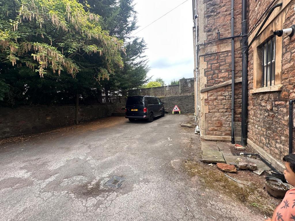 Private parking area beside a stone-built prope...