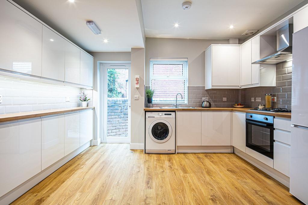 Modern and bright kitchen with white cabinetry,...