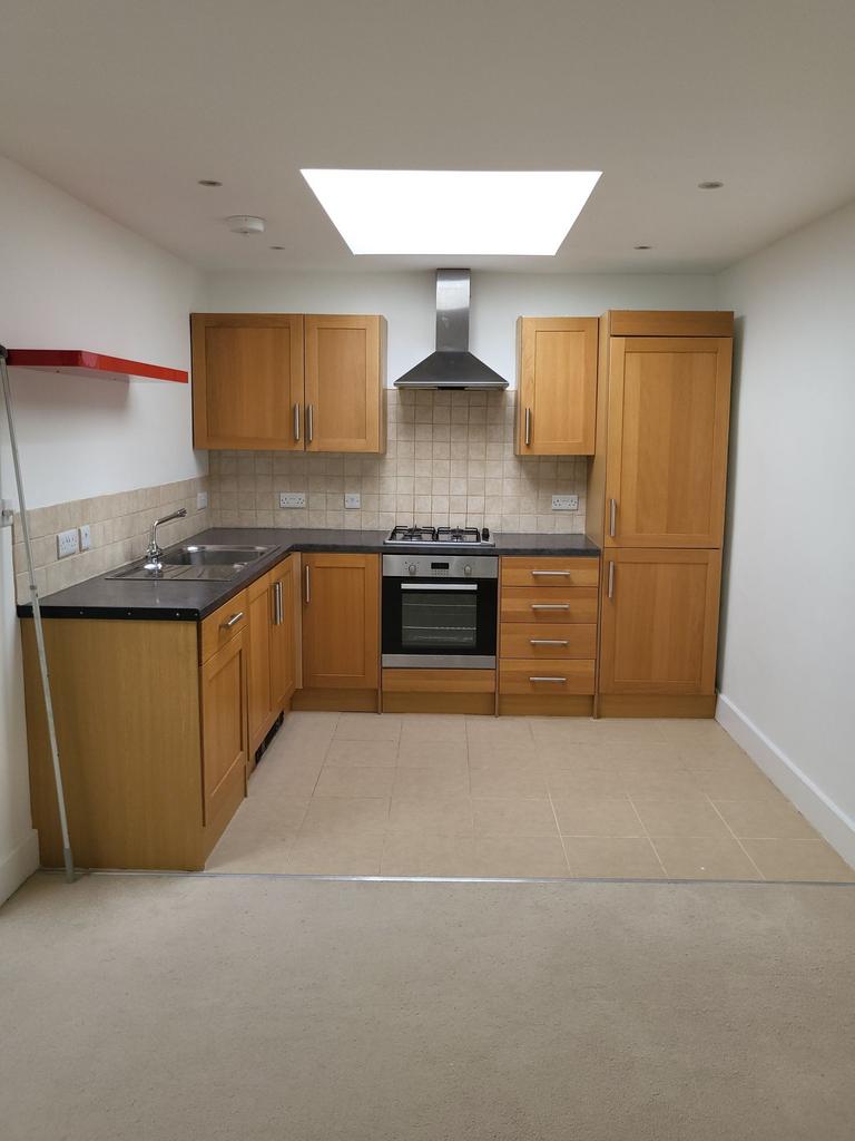 Bright, modern kitchen with timber cabinets, in...