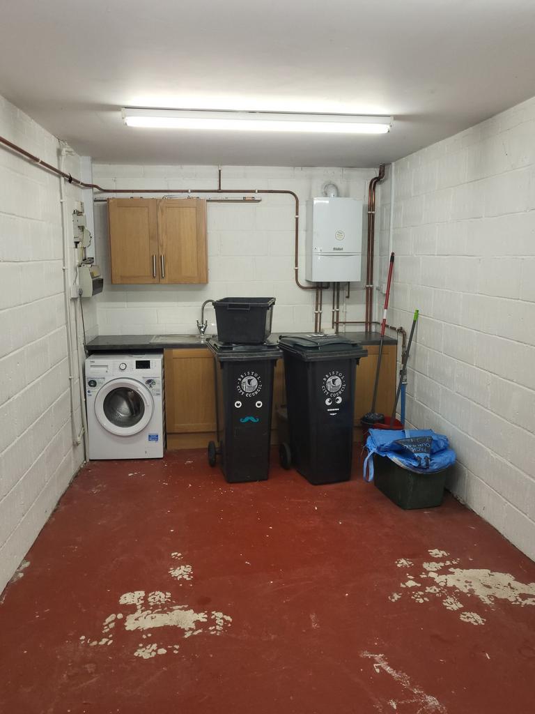 A tidy utility/storage room with a washing mach...