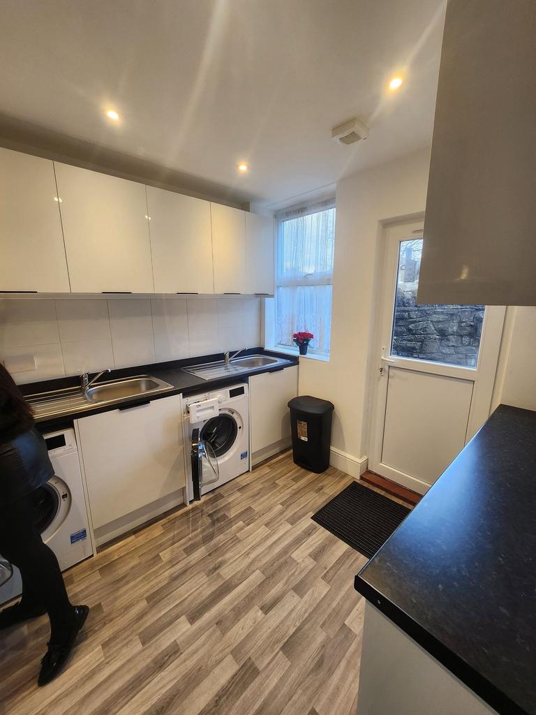 Bright, modern kitchen with glossy white cabine...