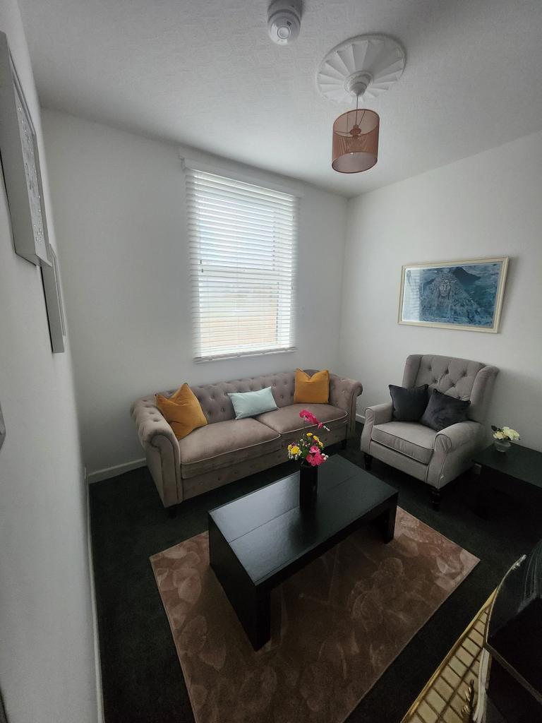 Bright, neatly furnished living room with a tuf...