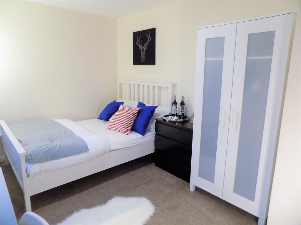 Bright, neatly presented bedroom with a white b...