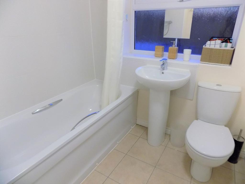 Bright, well-maintained bathroom with a white b...