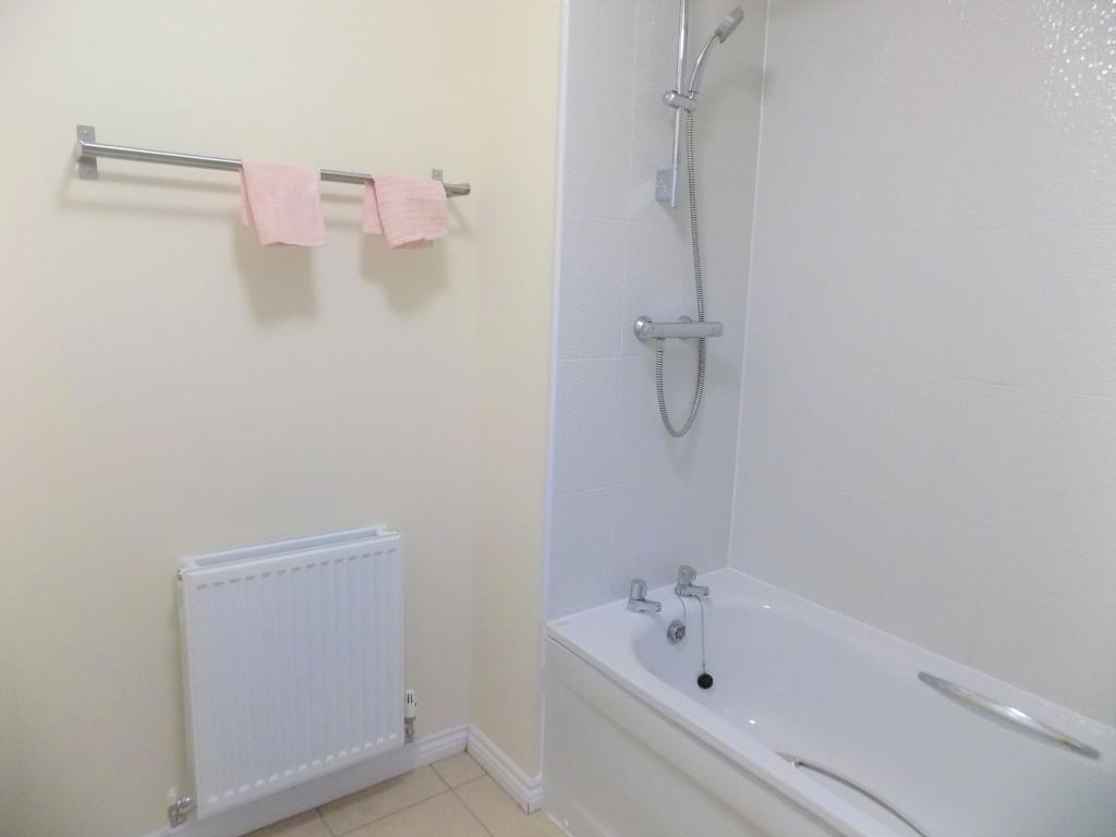 Bright, modern bathroom with a white bathtub an...