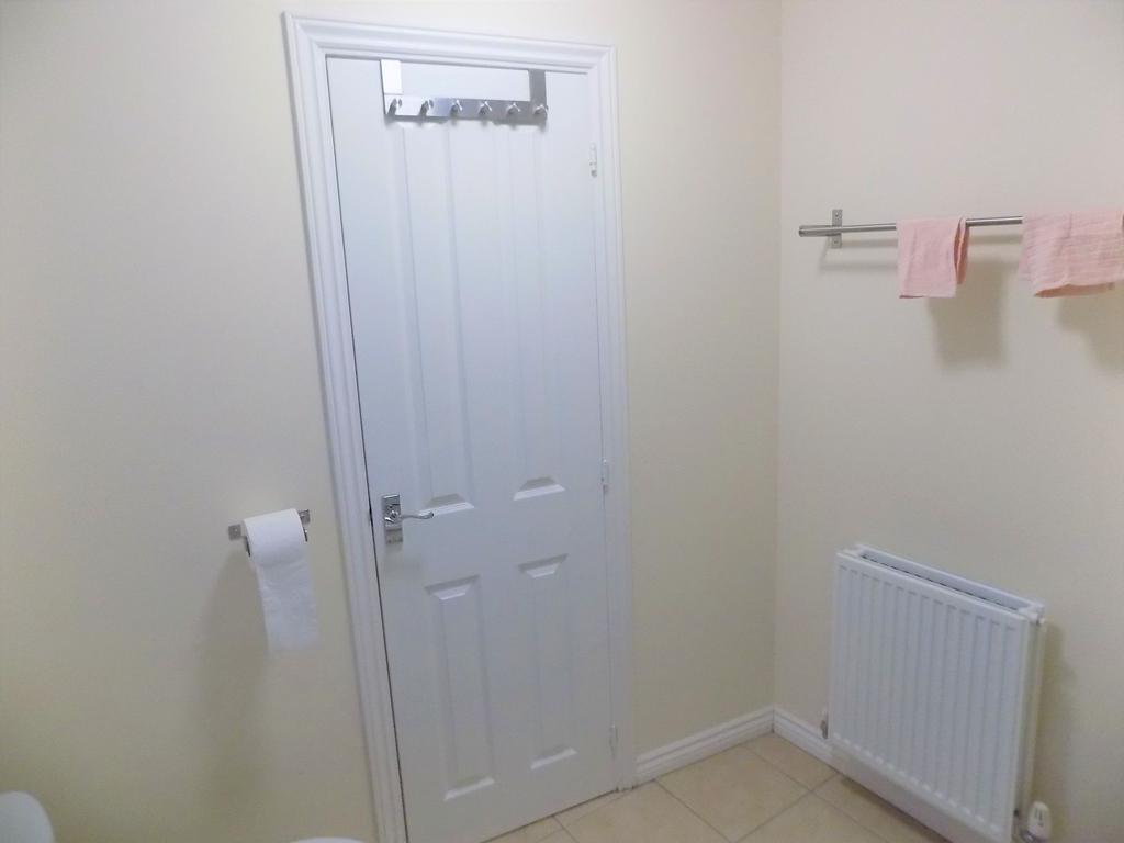 Neat, neutral bathroom with a white paneled doo...