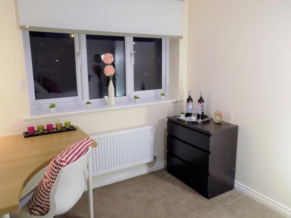 Bright, tidy bedroom corner with a desk by the ...