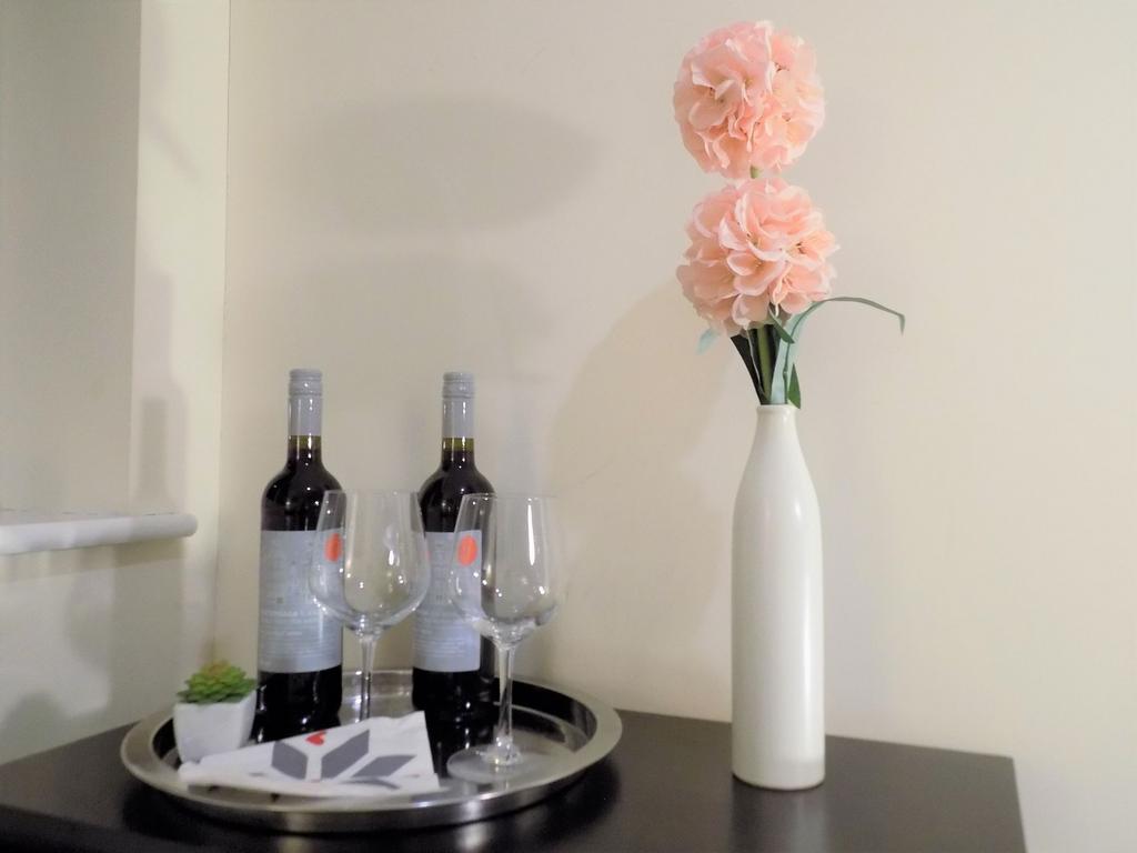 Styled corner with a tall white vase holding tw...