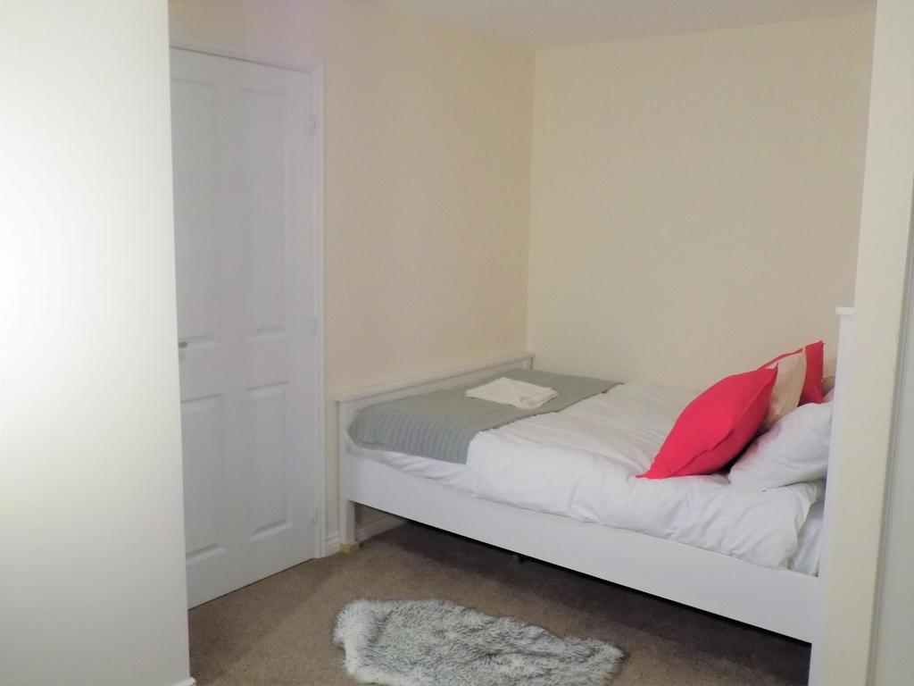 Neat single bedroom with a simple white bedfram...