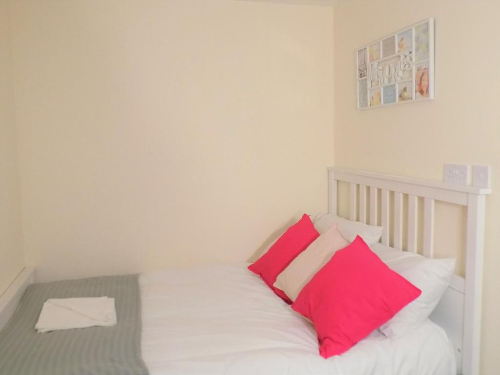 Bright, neatly made bedroom with a white slatte...