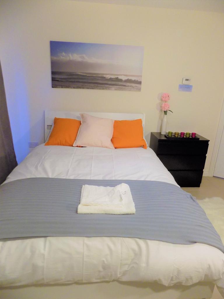 Bright, neatly made double bedroom with white b...
