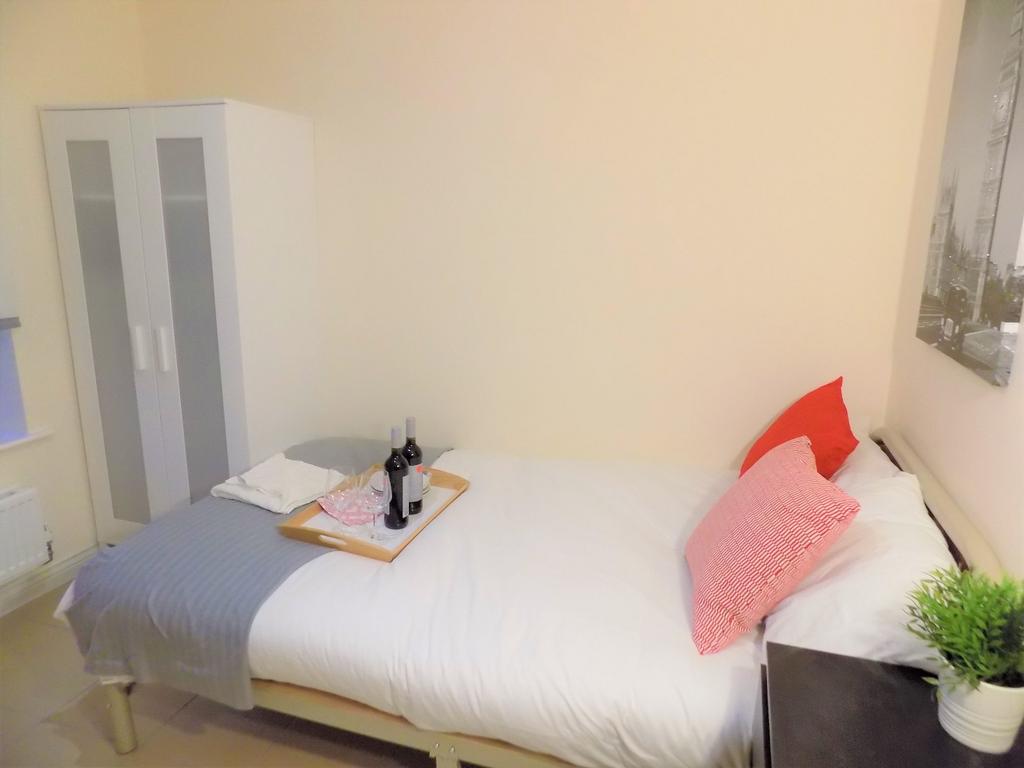 Bright, neatly made bedroom with a white duvet,...