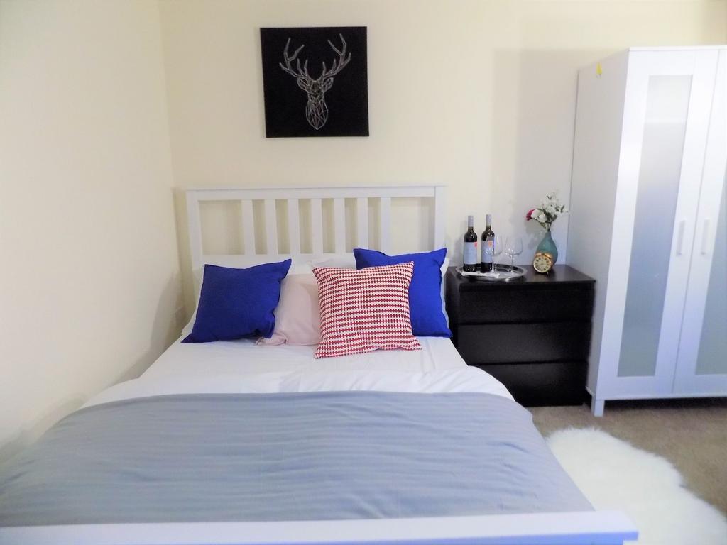 Bright, neatly styled bedroom with a white slat...