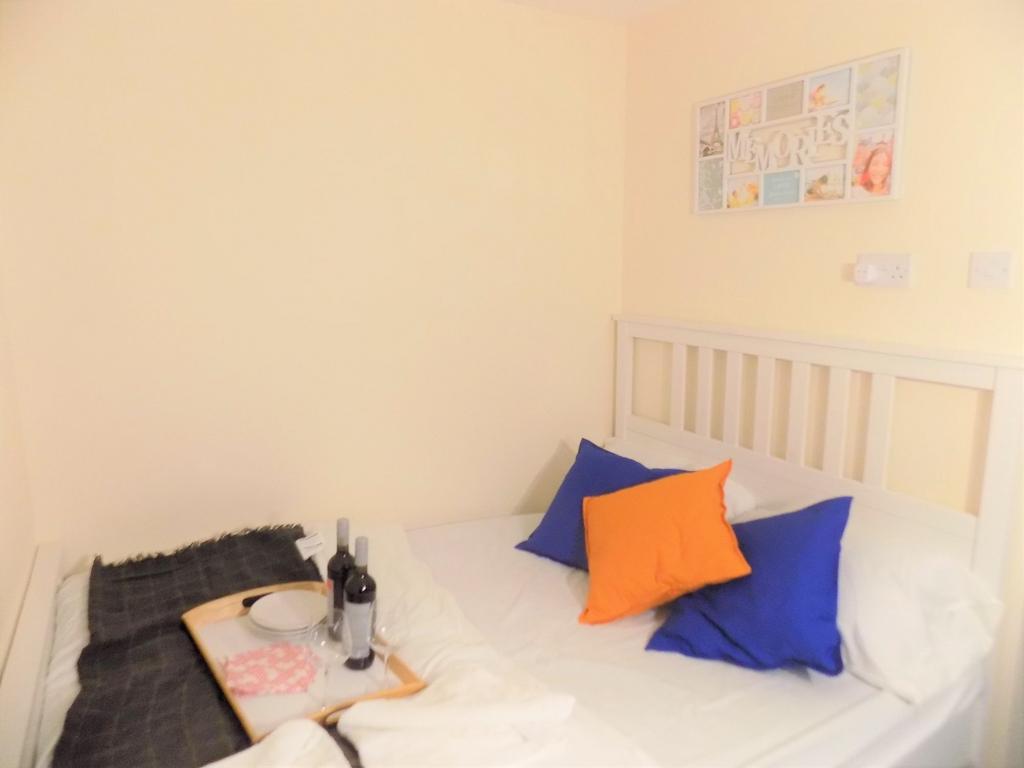 Cozy double bedroom with a white slatted headbo...