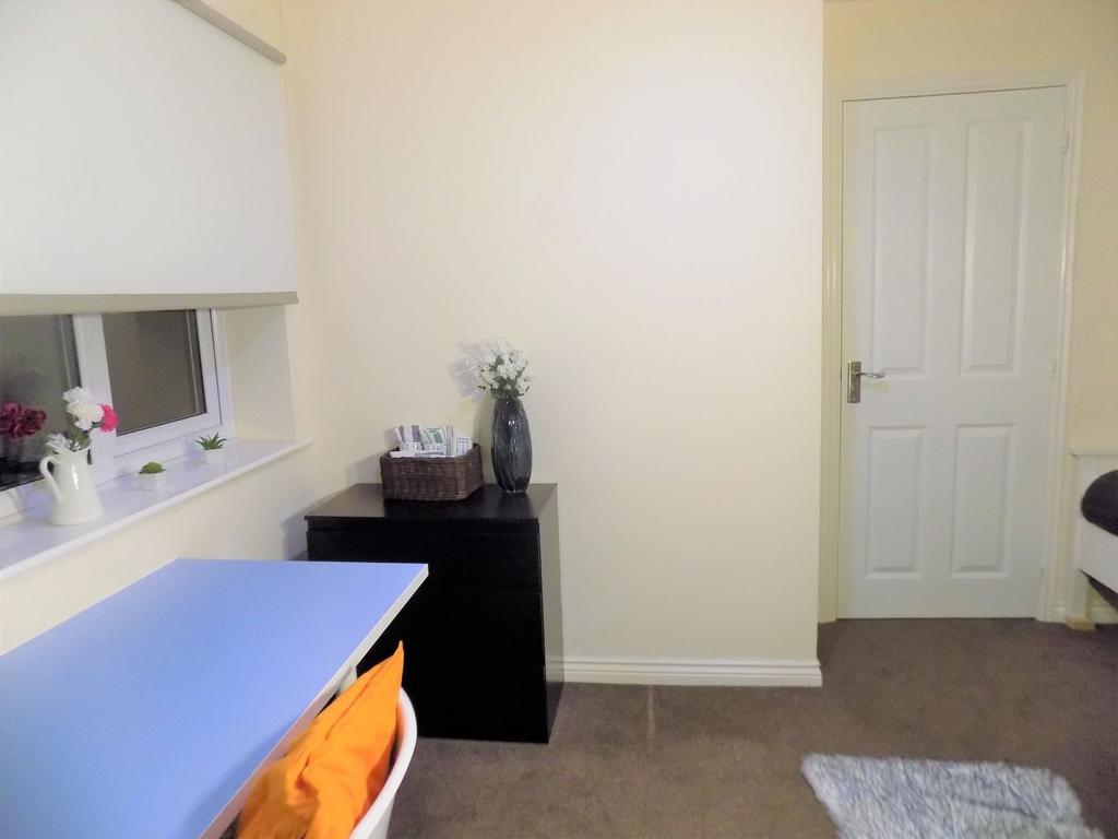 Bright, neutrally decorated bedroom with a stud...