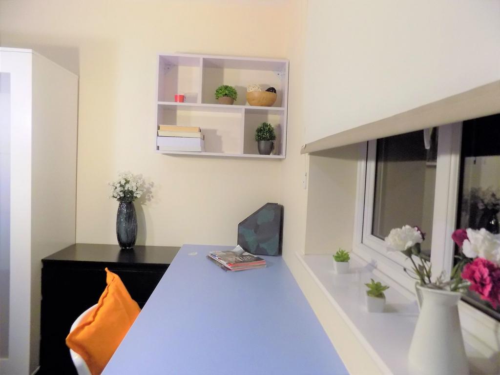 Bright study nook with a long desk surface by t...