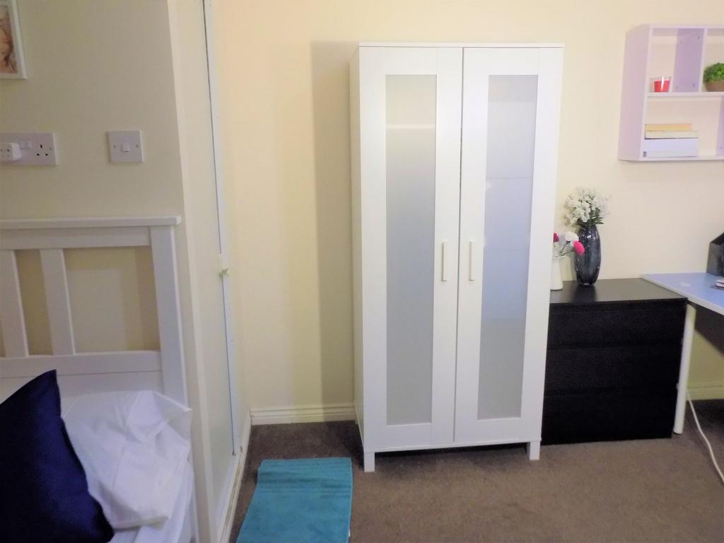 Bright, tidy bedroom with a modern white wardro...