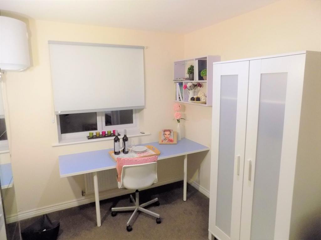 Bright, tidy bedroom corner with a long study d...