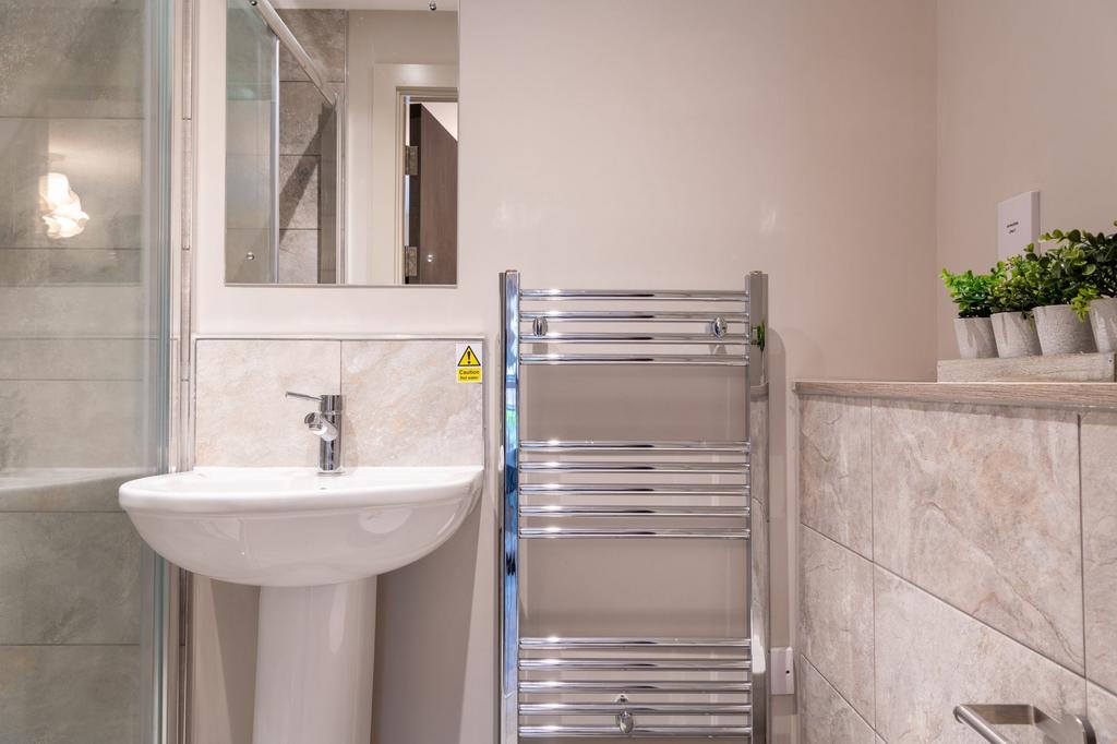 Bright, modern bathroom with a white pedestal s...