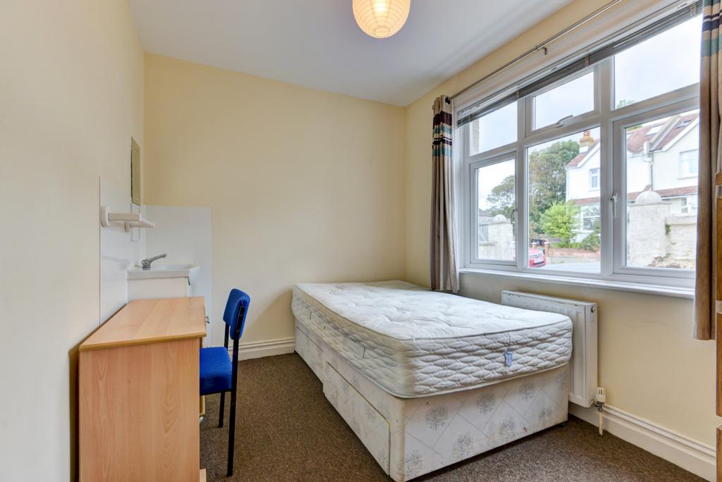 A cozy single bedroom featuring a comfortable b...