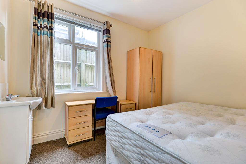 Bright, simply furnished bedroom with a large w...