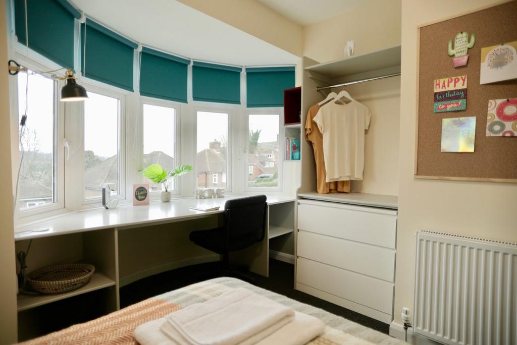 A bright and well-lit bedroom with a large bay ...