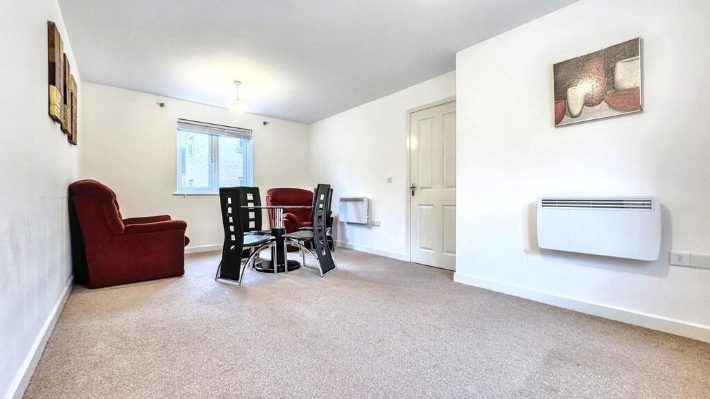 Bright, neutrally decorated living room with ca...