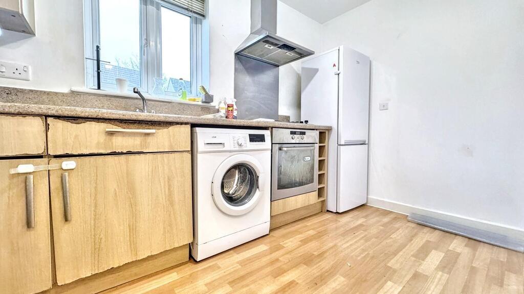 Bright, modern kitchen with light wood units, i...