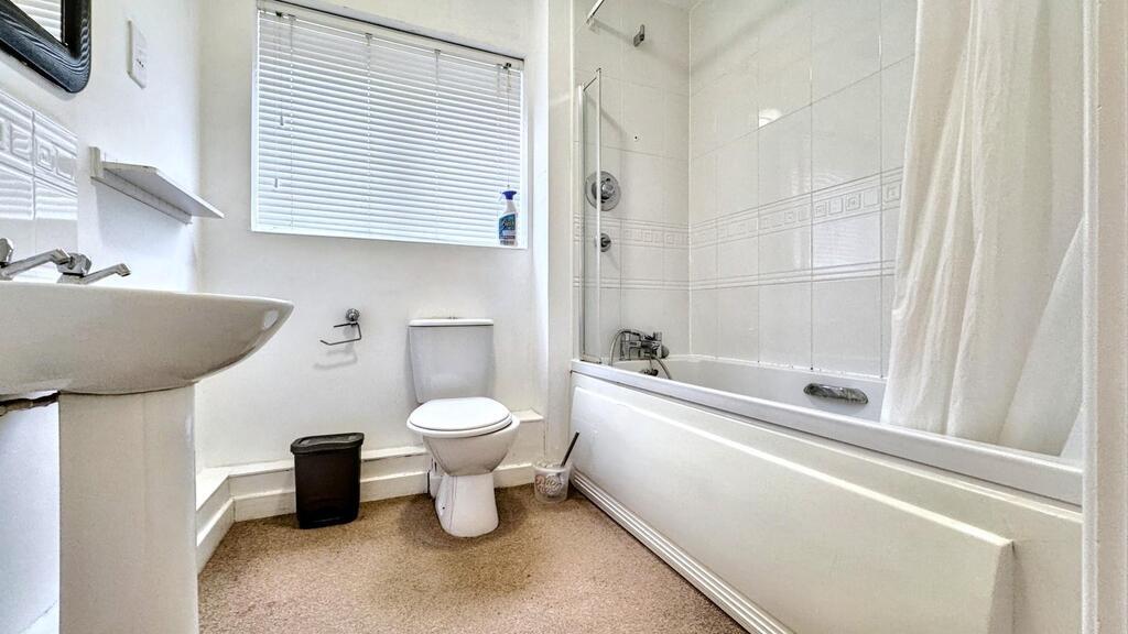 Bright, well-maintained bathroom featuring a fu...
