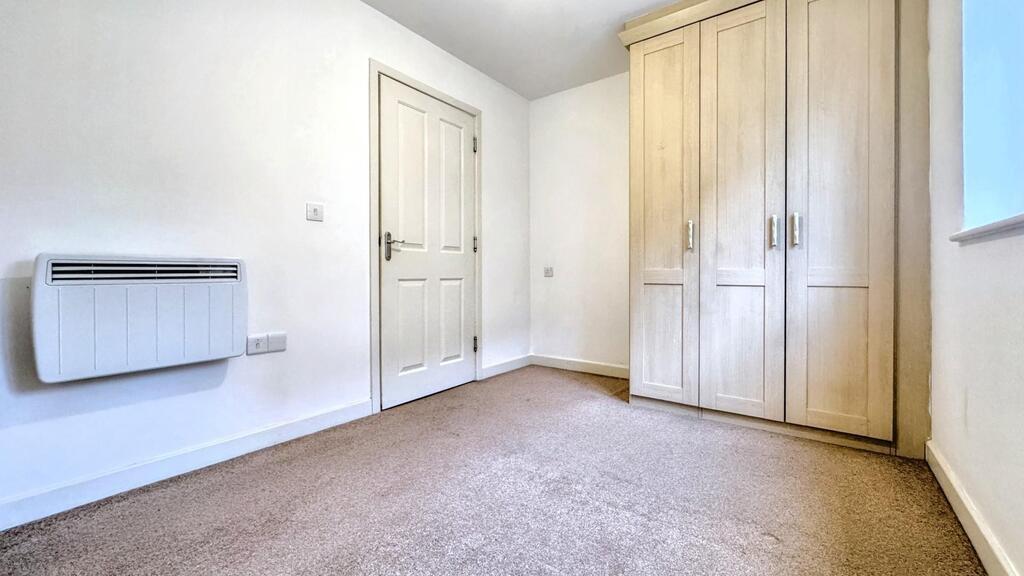 Bright, simply furnished bedroom with built-in ...