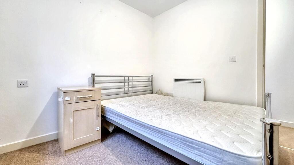 Neat single bedroom with a compact bed, simple ...