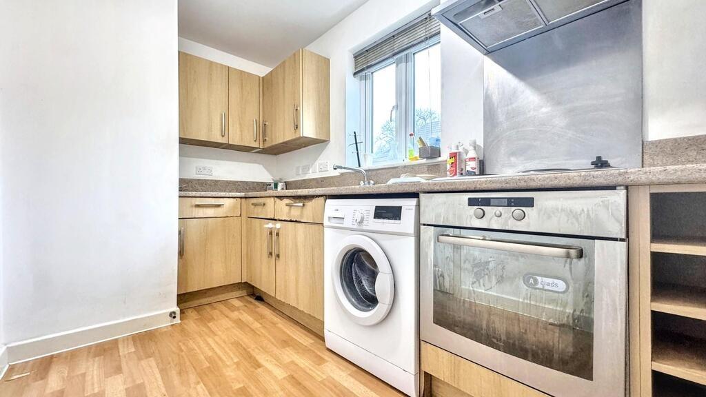Bright fitted kitchen with wooden cabinets, lam...
