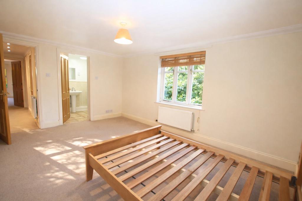 Sunlit bedroom with wooden bed frame