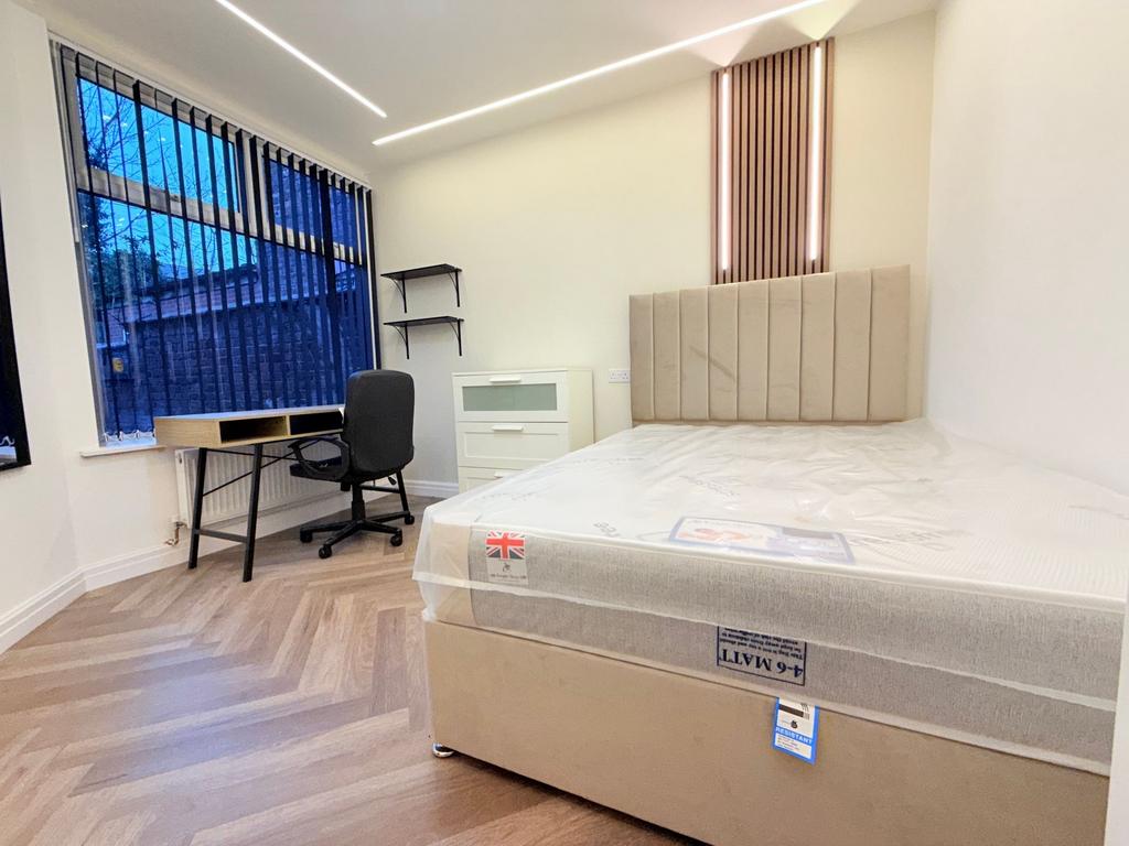 Bright, modern double bedroom with a plush upho...
