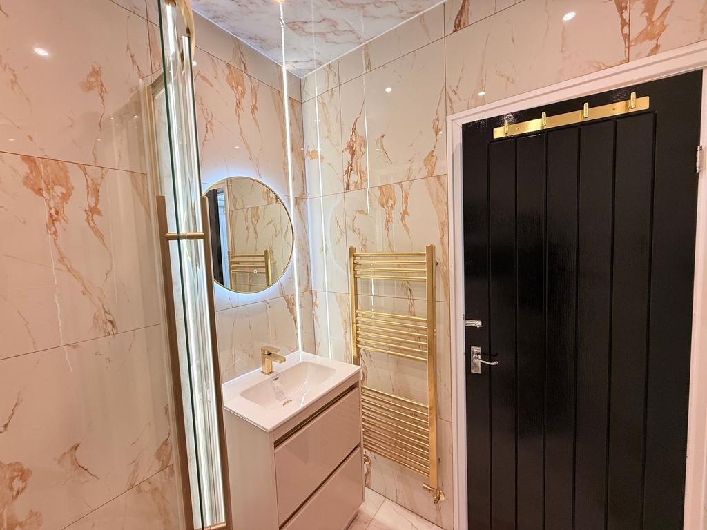 Stylish marble-tiled bathroom with a modern van...