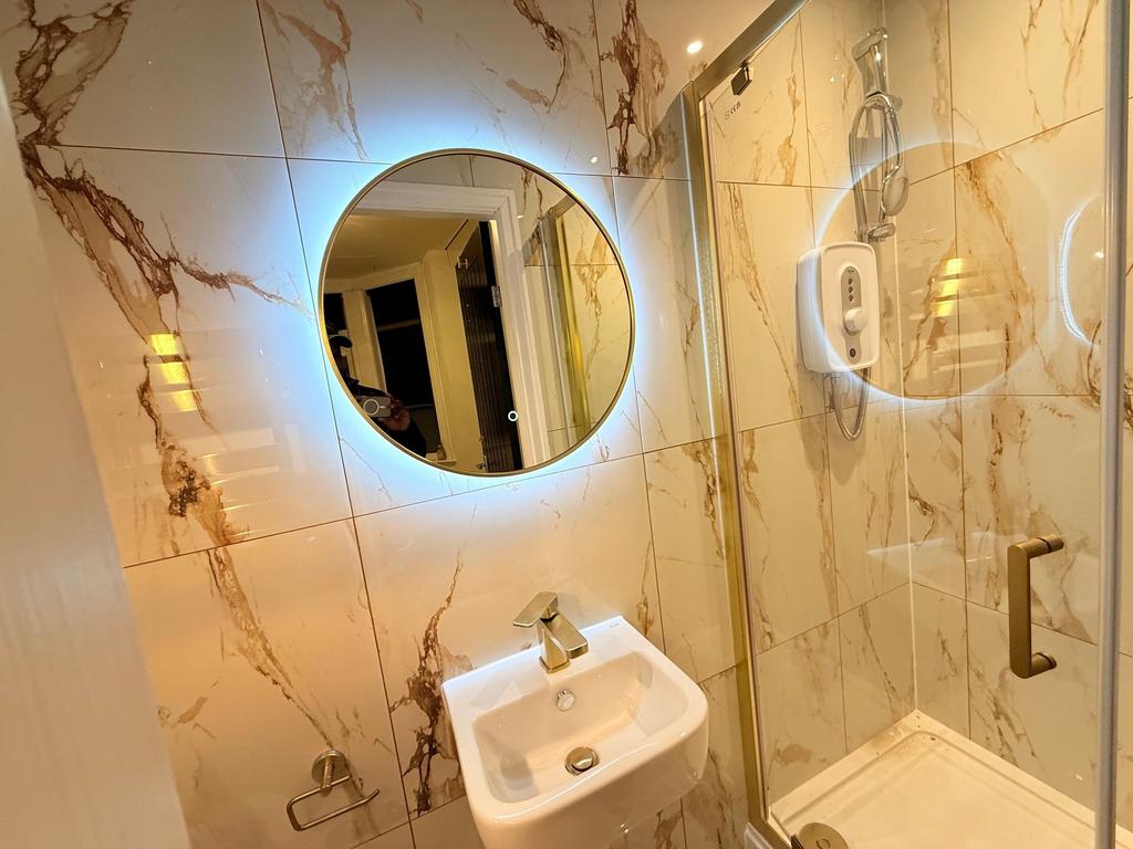 Contemporary tiled bathroom with a backlit roun...