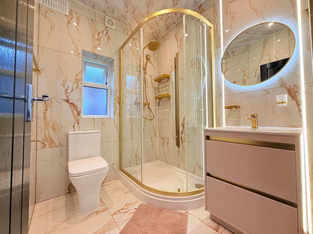 Bright, modern bathroom with a curved glass sho...