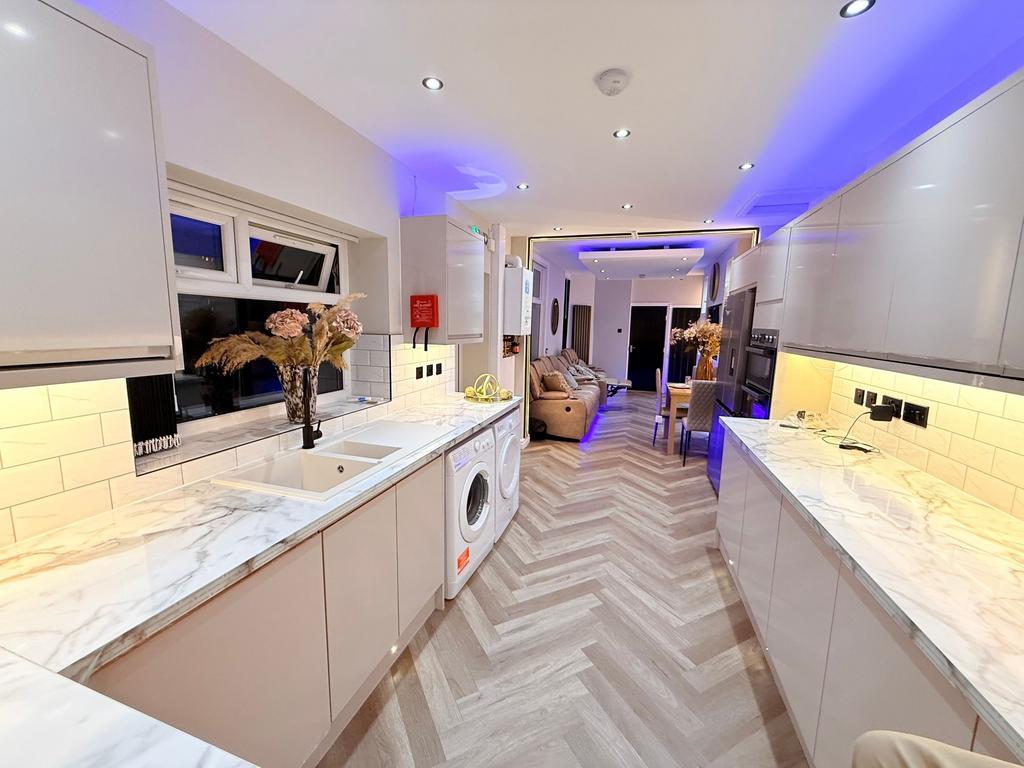 Contemporary galley kitchen with glossy marble-...