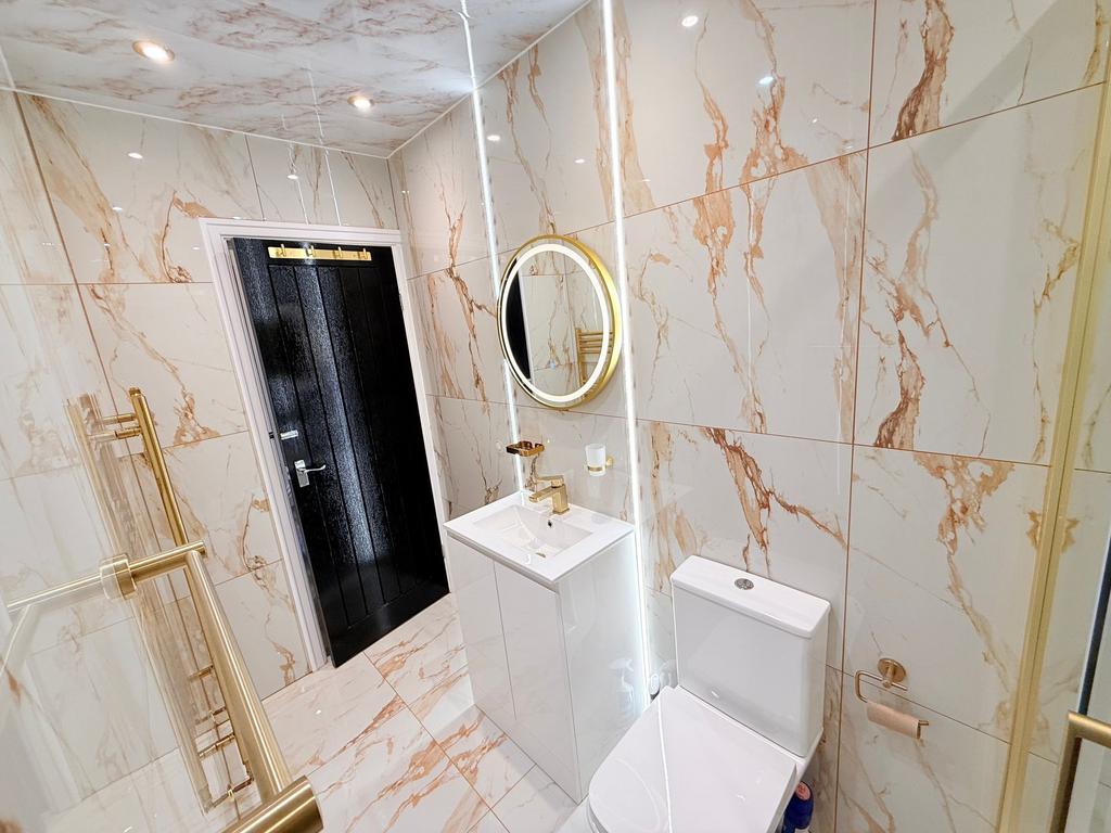 Bright, modern bathroom with glossy marble-effe...