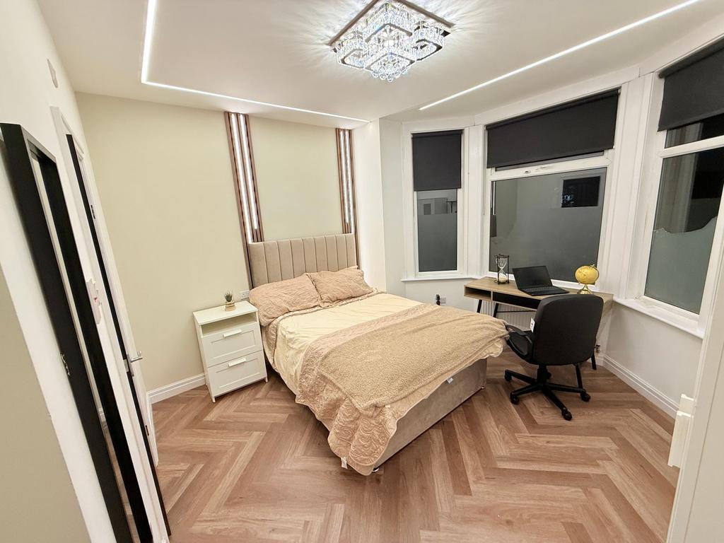 Bright, modern double bedroom with a padded hea...