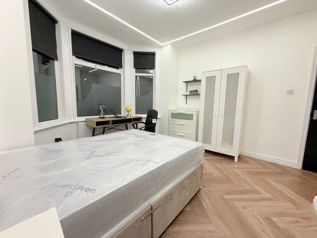 Bright, modern bedroom with a large bay window,...