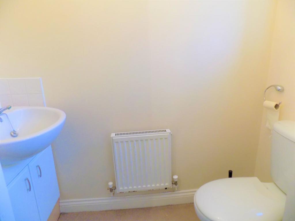 A clean and simple toilet room featuring a whit...