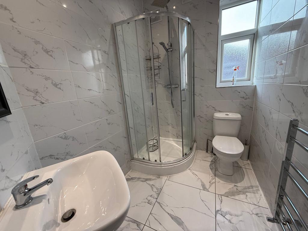 Bright, modern bathroom with a corner glass sho...