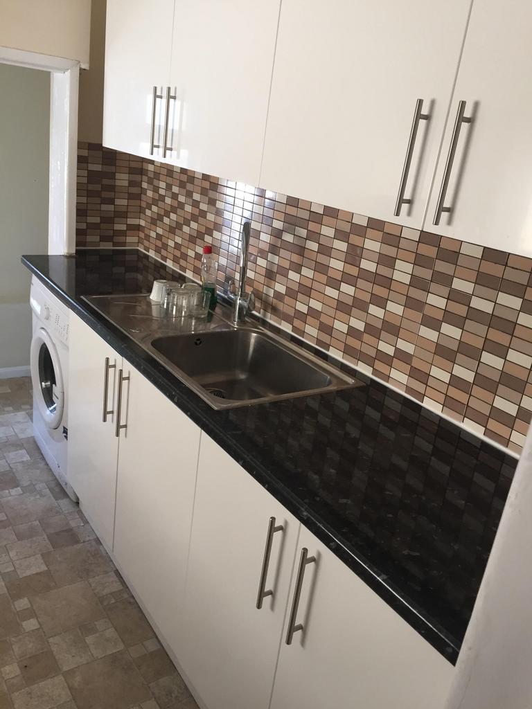 A clean kitchen with modern cabinetry and a was...