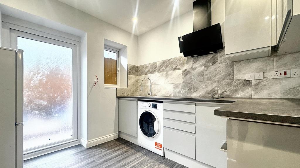 Bright modern kitchen with white cabinets, marb...