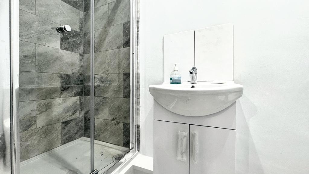 Bright, modern bathroom with a glass-enclosed s...