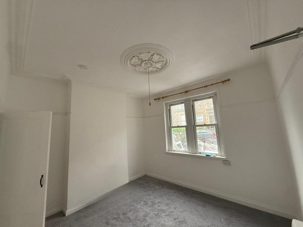 Bright, neutral single bedroom with a decorativ...