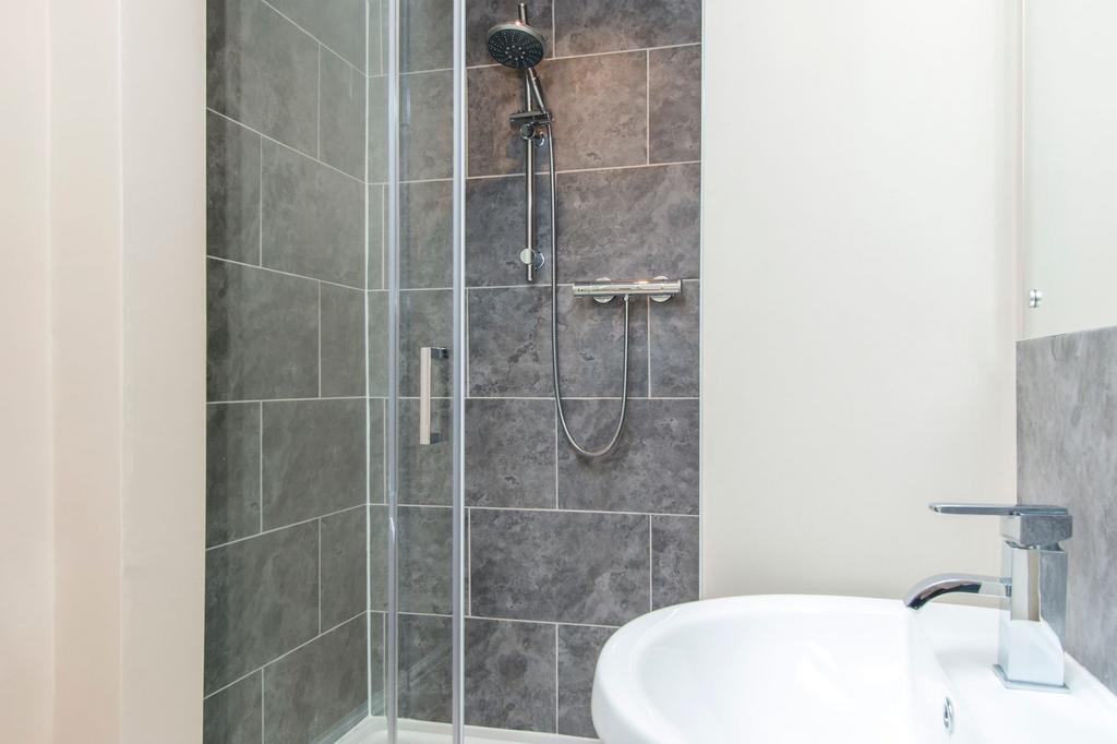 Modern en-suite bathroom with a tiled walk-in s...